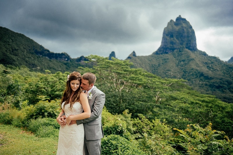 Couple posing under the rain on their wedding day in Moorea